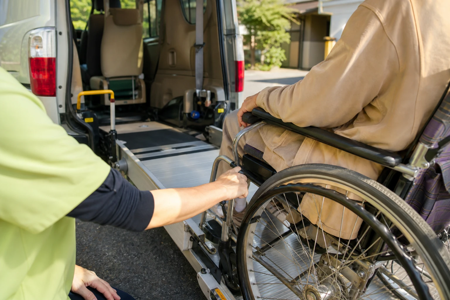 後部リフトで、車いすに座ったままの方をゆっくり車内へ上げる介助スタッフ